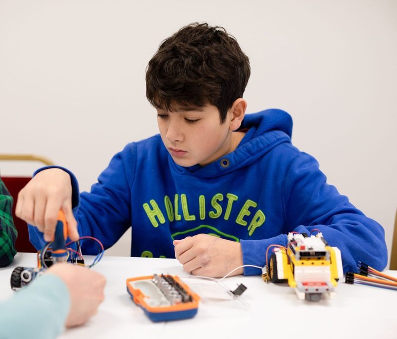 Student building a robot in class